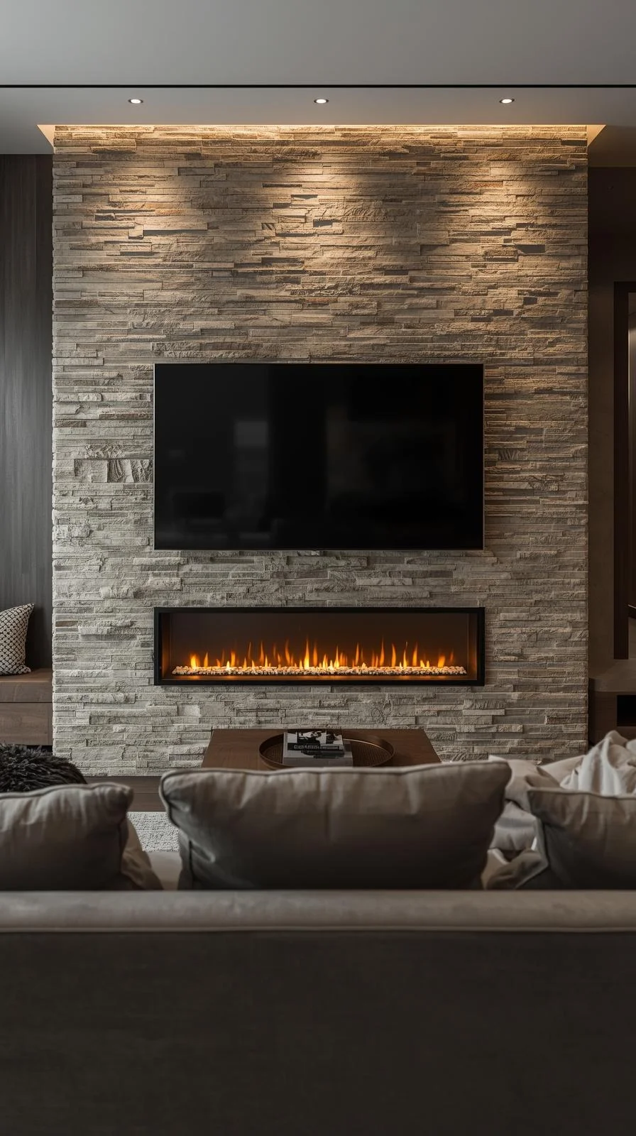 Living room with a large TV mounted above a fireplace featuring a full-height stone surround.